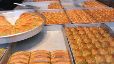 Bir fırında servis edilen çeşitli baklava türlerini görünce keyifleniyorlar..