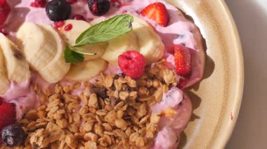 Muz, böğürtlen ve gevrek taneli lezzetli yoğurt kasesi taze servis ediliyor..