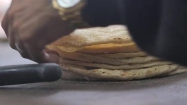 Bir şef ahşap bir yüzeye ustalıkla taze ekmek serpiştirir..