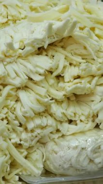 Canlı bir mutfak alanında taze peynir kesilip hazırlanıyor..