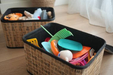 Parlak renkli oyuncaklar rahat bir oyun alanında iki sepet doldurur..