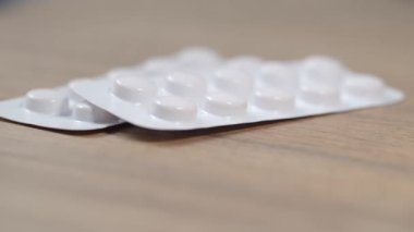 Tahta bir masanın üzerinde duran su toplamalı tabletlerin yakın plan görüntüsü..