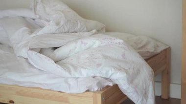 Sabahın erken saatlerinde dağınık yataklı, rahat bir yatak odası..