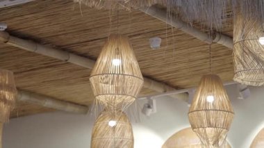 Konforlu kafe tavandan sarkan eşsiz dokuma lambalar sergiliyor..