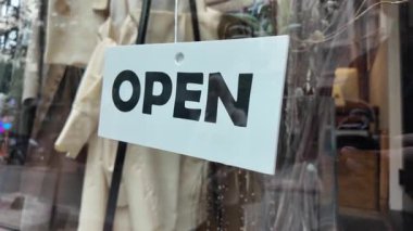 Parlak bir açık tabela müşterileri büyüleyici bir dükkânı keşfetmeye davet eder..