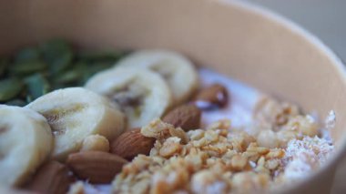 Meyve ve fındık dolu besleyici bir kahvaltı kasesinin tadını çıkarın..