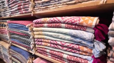 Havlular bir dükkandaki ahşap raflara düzgünce istiflenir..