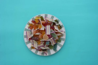 Çeşitli şekerleme çeşitleri mavi arka planda çizgili bir tabakta oturur..