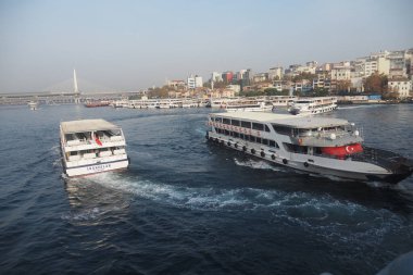 İstanbul 'da sularda iki tekne hareket ederken, belediye binaları da görülüyor..
