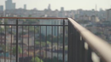 Kamera, aşağıdaki canlı şehri gösteren geniş bir balkon görüntüsünü yakalar..