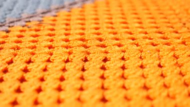 Benzersiz bir deseni olan dokulu turuncu kumaşın canlı detaylarını keşfet..