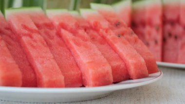 Güneşli bir piknik sırasında taze karpuz dilimleri tabakta servis edilir..
