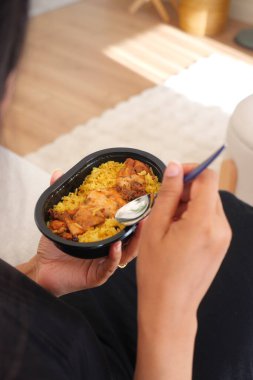 Bir insan evinde lezzetli bir tabak pirinç ve tavuk yer..