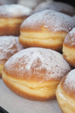 Yumuşak, pudra şekerli pofuduk çörekler cazip ve eğlenmeye hazır..