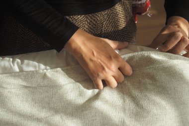 Öğleden sonra, aydınlık bir odada, insanlar düz kumaşlar kullanır..