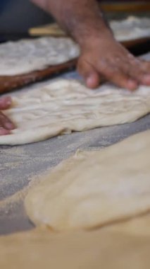 Yetenekli bir fırıncı sıcak bir fırında hamur şekillendirir..