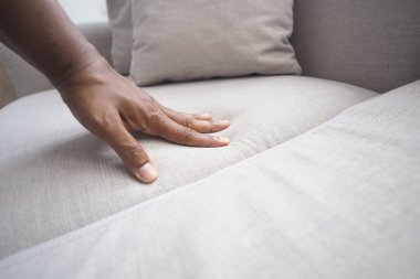 Çağdaş bir kanepenin yumuşak kumaşına bir el bastırıyor..