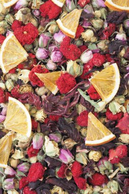 Renkli bir kurutulmuş çiçek ve portakal dilimi karışımı sahneyi dolduruyor..