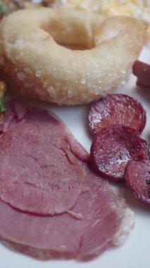 Lezzetli bir brunch 'ın tadını çıkarın et dilimleri ve tatlı hamur işleriyle.