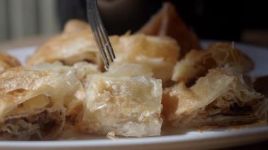 Sıcak bir kafe ortamında lezzetli borek ısırıklarının tadını çıkarıyorum..