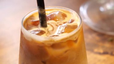 Lezzetli bir buzlu kahve sıcak bir kafede pipet ve buzla hazırlanır..