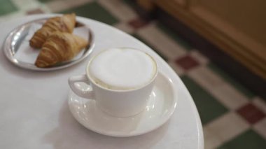 Bir kafede köpüklü süt ve lezzetli kruvasanlarla kahve yudumlamak..