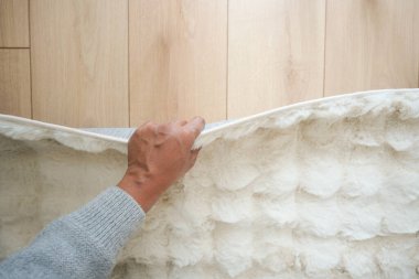 Bir el, yumuşak ahşap zemin yüzeyinden sıcacık bir halı çeker..