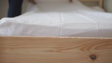 Rahat bir yer yaratmak için yatağa yeni çarşaflar konur..