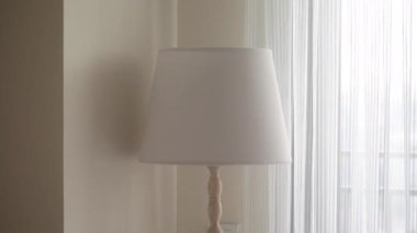 Modern bir lamba pencerenin yanındaki ışık dolu odayı aydınlatır..