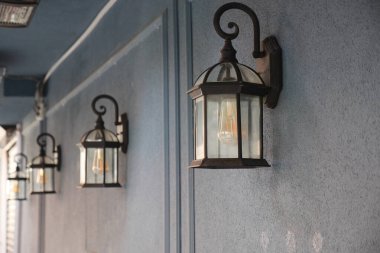 Dekoratif lambalardan gelen hafif ışık geceleri mavi bir duvarı aydınlatır..