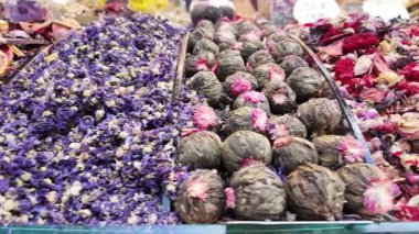 Parlak bitkiler ve çiçekler market tezgahını dolduruyor, canlı renkler sergiliyor.