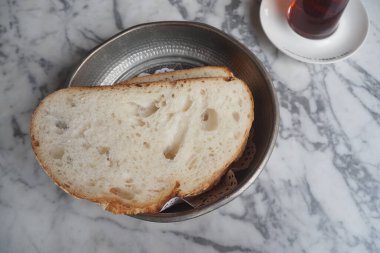 Sıcak ekmek dilimleri bir fincan çayın yanına konur..