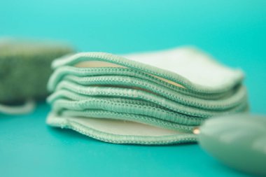 Mavi yüzey üzerindeki renkli bez pedler çevre dostu tasarımı vurguluyor.