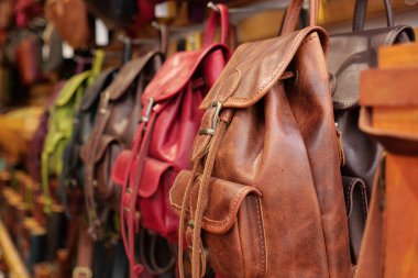 Renkli deri sırt çantaları bir markette güzelce sergileniyor..