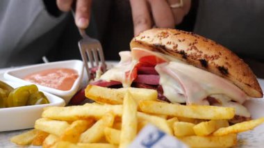 Eritilmiş peynirli ve patatesli lezzetli bir sandviç servis ediliyor..