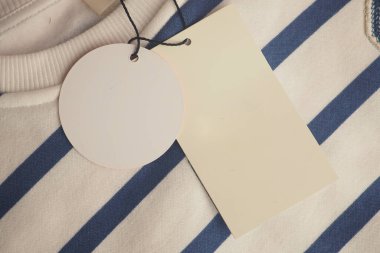 Çizgili kumaş üzerindeki bir giyim etiketinin yakın plan görüntüsü.