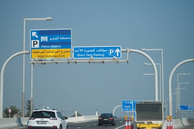 Yol işaretleri, araçları metro istasyonuna ve kısa süreli park yerine yönlendiriyor..