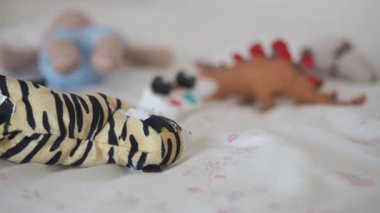 Çocuklar, parlak bir odada yumuşak oyuncaklarıyla neşeli anların tadını çıkarırlar..