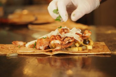 Şef taze malzemelerle bir tavuk dürümü hazırlıyor. ,