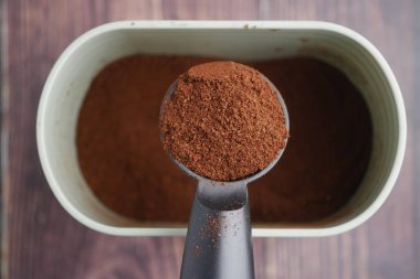 Kahve telvesiyle doldurulmuş bir ölçü kepçesi konteynırın üstündedir..