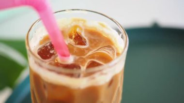 Pembe pipetle servis edilen buzlu kahve, yaz günleri için mükemmel..