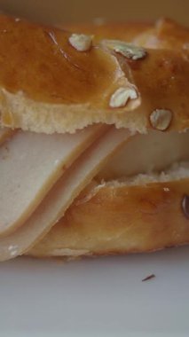 Hindi dilimleri ve yulaflarla dolu yumuşak bir ekmek rulosunun yakın plan görüntüsü..