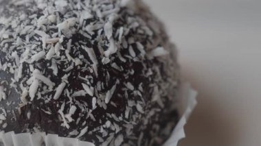 Hindistan cevizi tanecikleriyle kaplı bir tatlı topunun yakın plan görüntüsü..