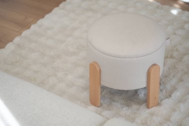 Yuvarlak, beyaz bir sedir pofuduk bir halının üzerinde, aydınlık bir yaşam alanında..