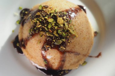 Tatlı bir ikram. Çikolata ve şam fıstığı serpiştirilmiş yuvarlak bir tatlı..