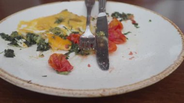 Çatallı bir tabakta yumurta ve domates de dahil..