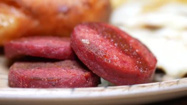 Tabağında yumurta ve ekmek olan sosis dilimine yakın plan. .