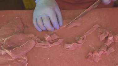 Bir kasap ustalıkla eti dilimler ve farklı şekillerde keser..