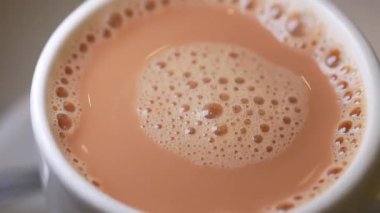 Sabahları sıcak bir fincan sütlü çayın tadını çıkarıyorum..