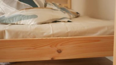 Temiz çarşaflar rahat bir yatak odasındaki bir yatağa konur..